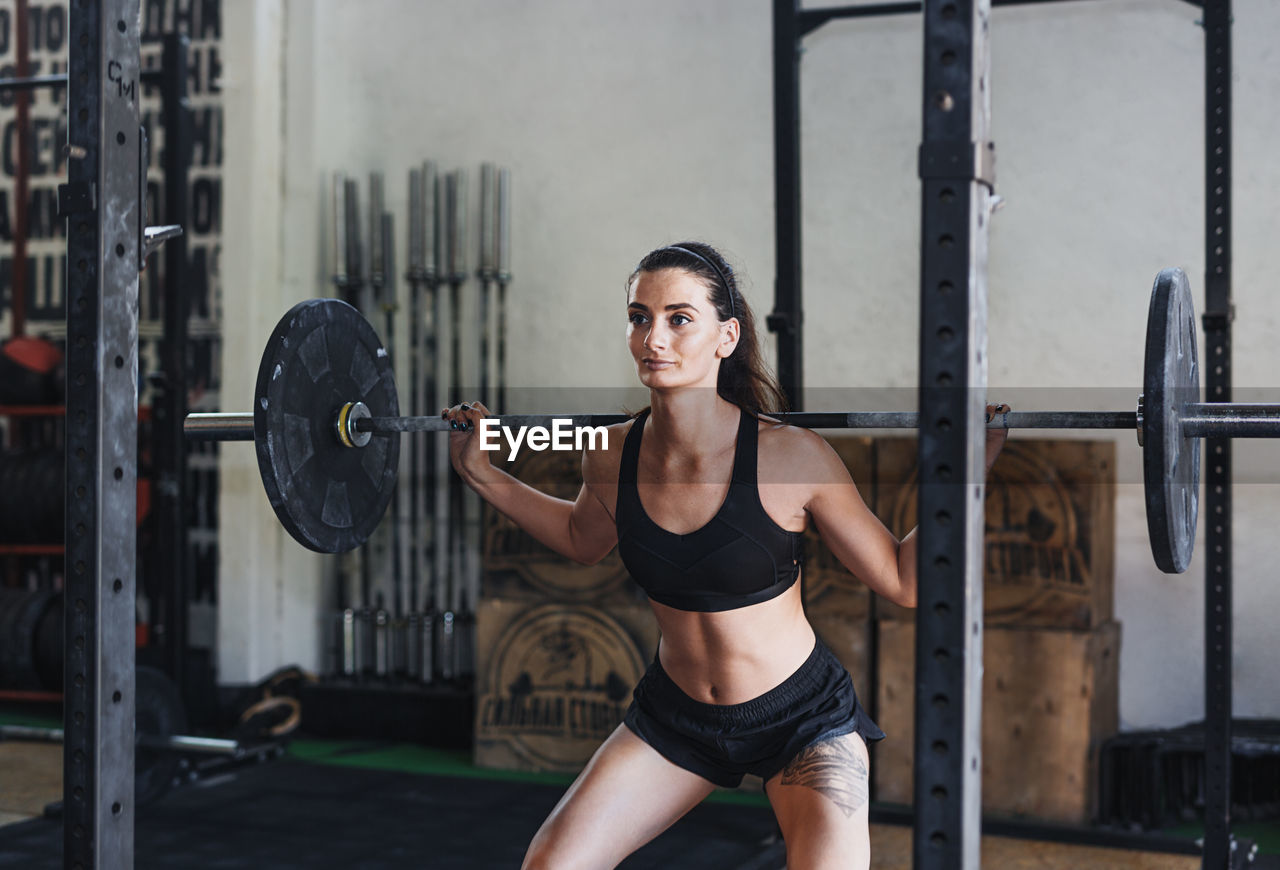 Woman lifting barbell in gym