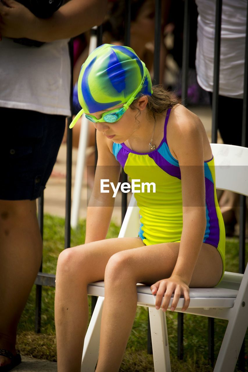 Girl sitting in swimwear sitting on chair