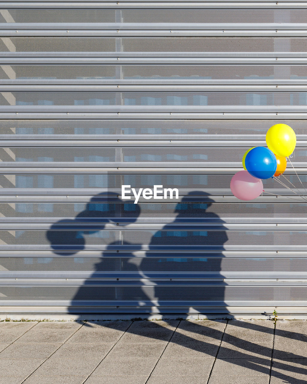 Shadow of people with balloon on shutter