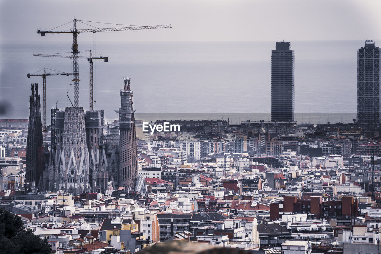 Aerial view of buildings in city against sky