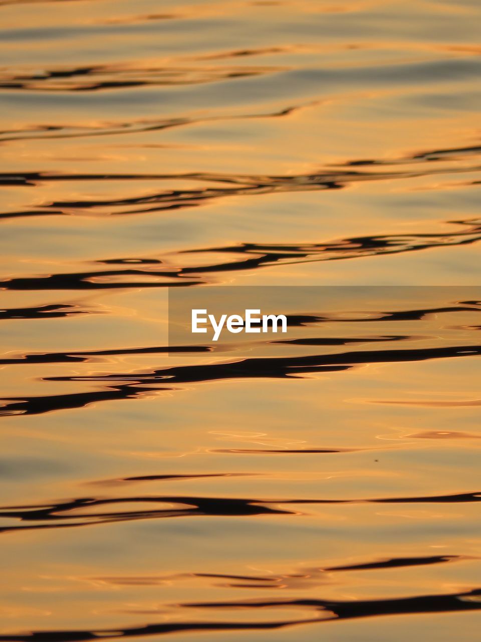 Full frame shot of sky reflection on water during sunset