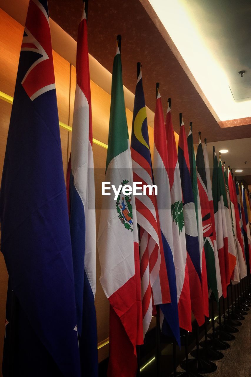 CLOSE-UP OF MULTI COLORED FLAGS HANGING ON WALL