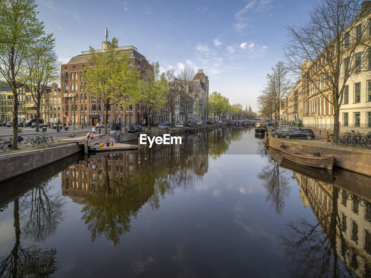 Canal amidst buildings against sky