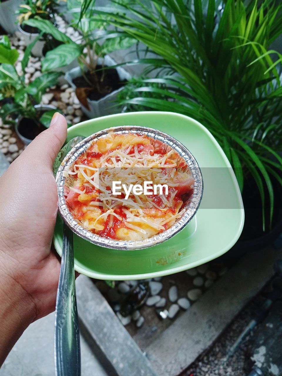 HIGH ANGLE VIEW OF PERSON HAND HOLDING FOOD