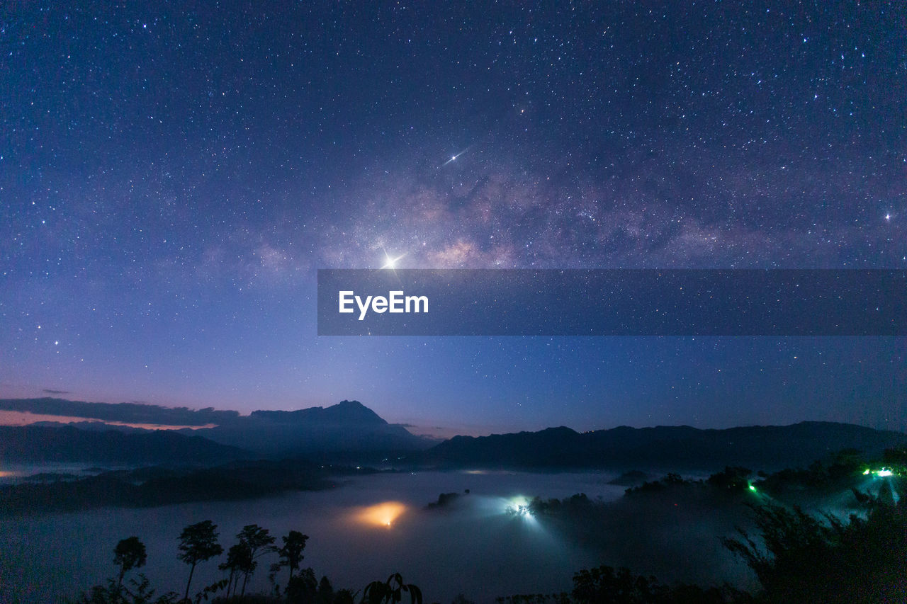 SCENIC VIEW OF ILLUMINATED MOUNTAIN AGAINST SKY AT NIGHT