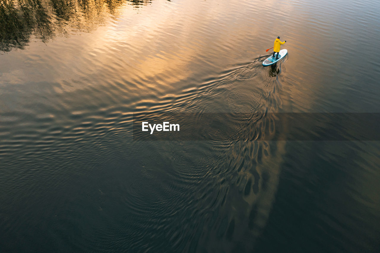 Man sup surfer on the river in winter on sup