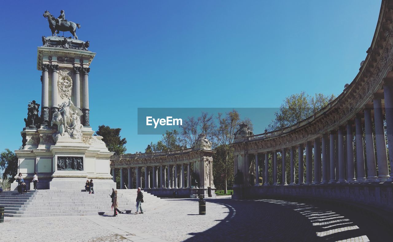 People at monument to alfonso xii in parque del buen retiro