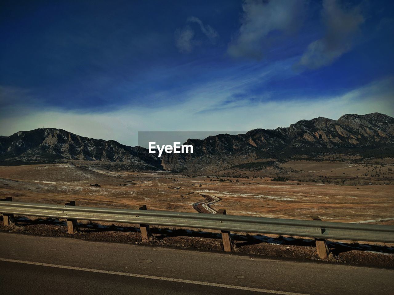 Road by mountains against sky