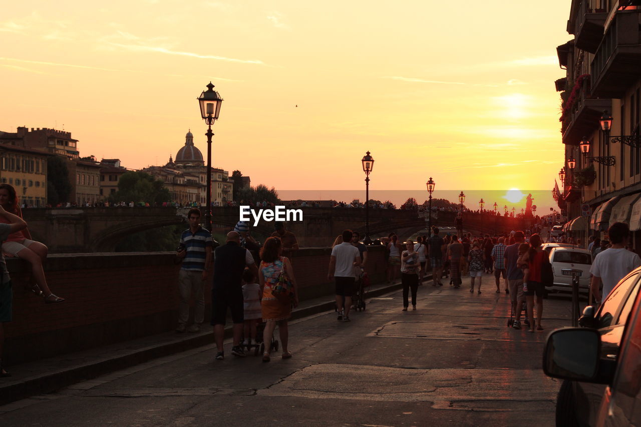 People walking on street during sunset