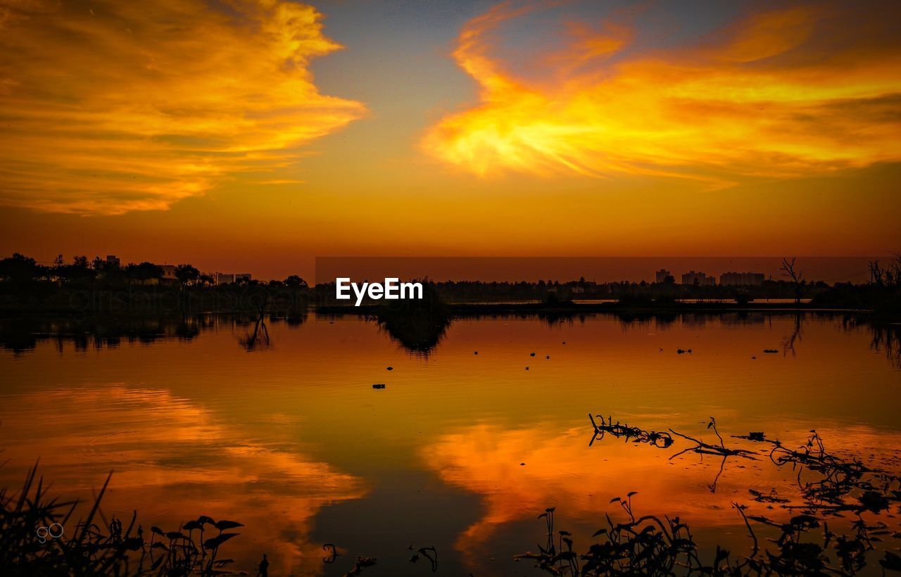 Scenic view of lake against orange sky