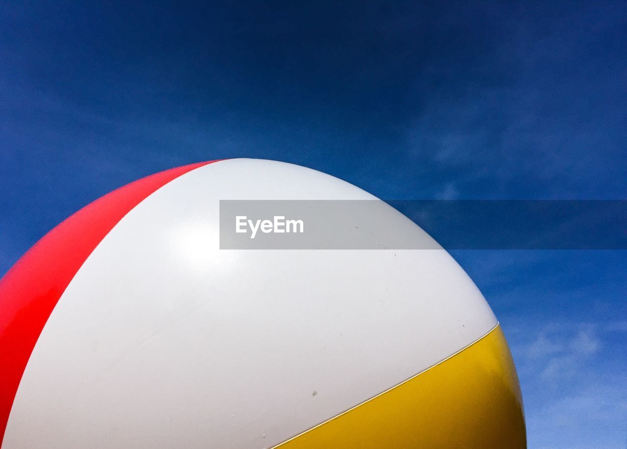 Low angle view of ball against blue sky on sunny day