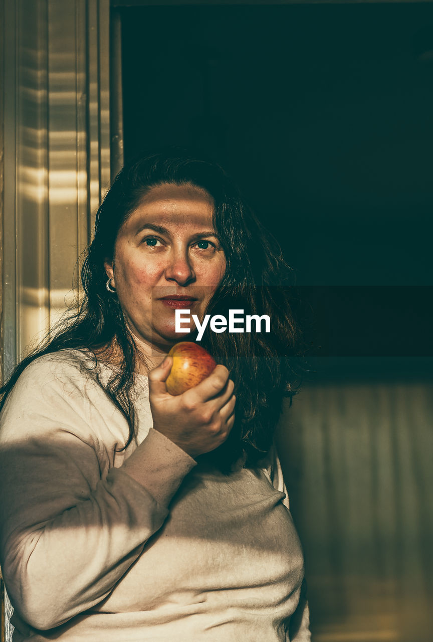 Portrait of woman holding apple