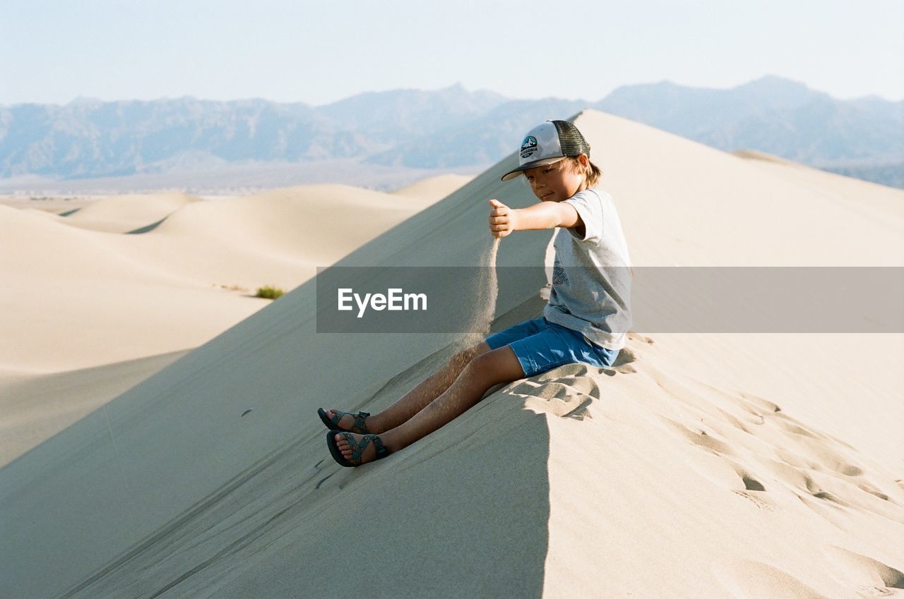 Rear view of boy on desert