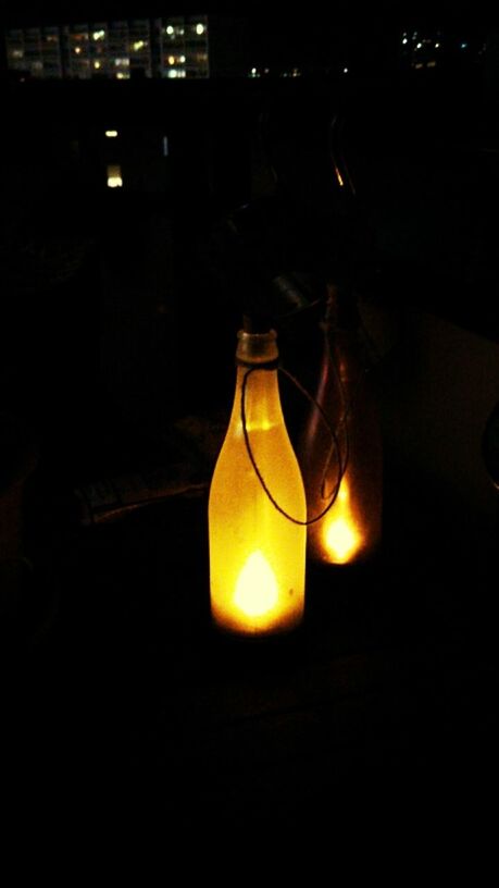 CLOSE-UP OF LIT CANDLES IN DARK ROOM