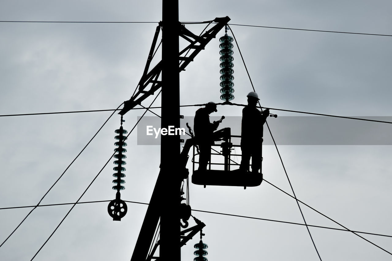 Low angle view of electricity pylon against sky