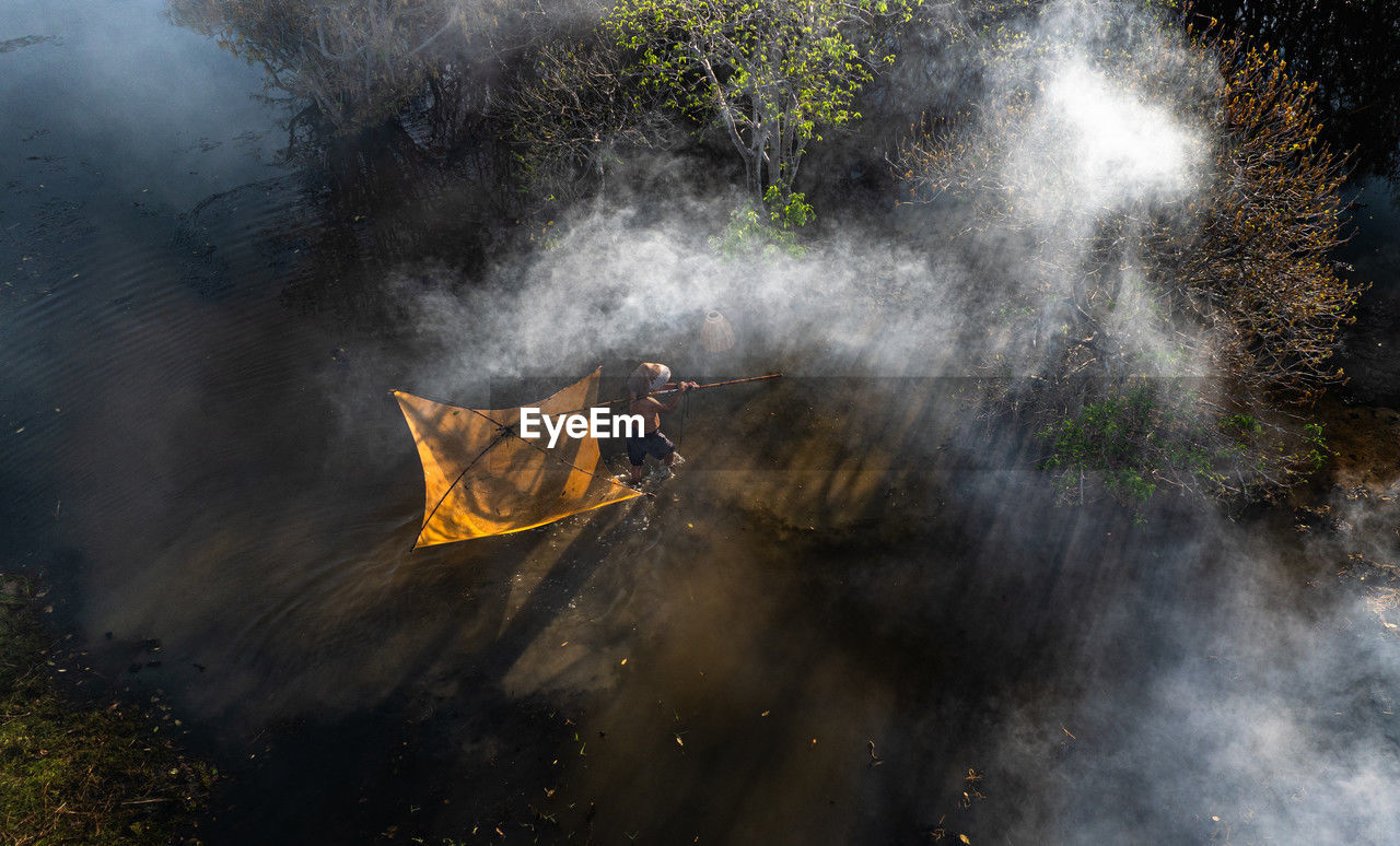 water, nature, screenshot, fog, environment, outdoors, reflection, plant, fire, no people, occupation, smoke, sunlight, motion, morning, high angle view