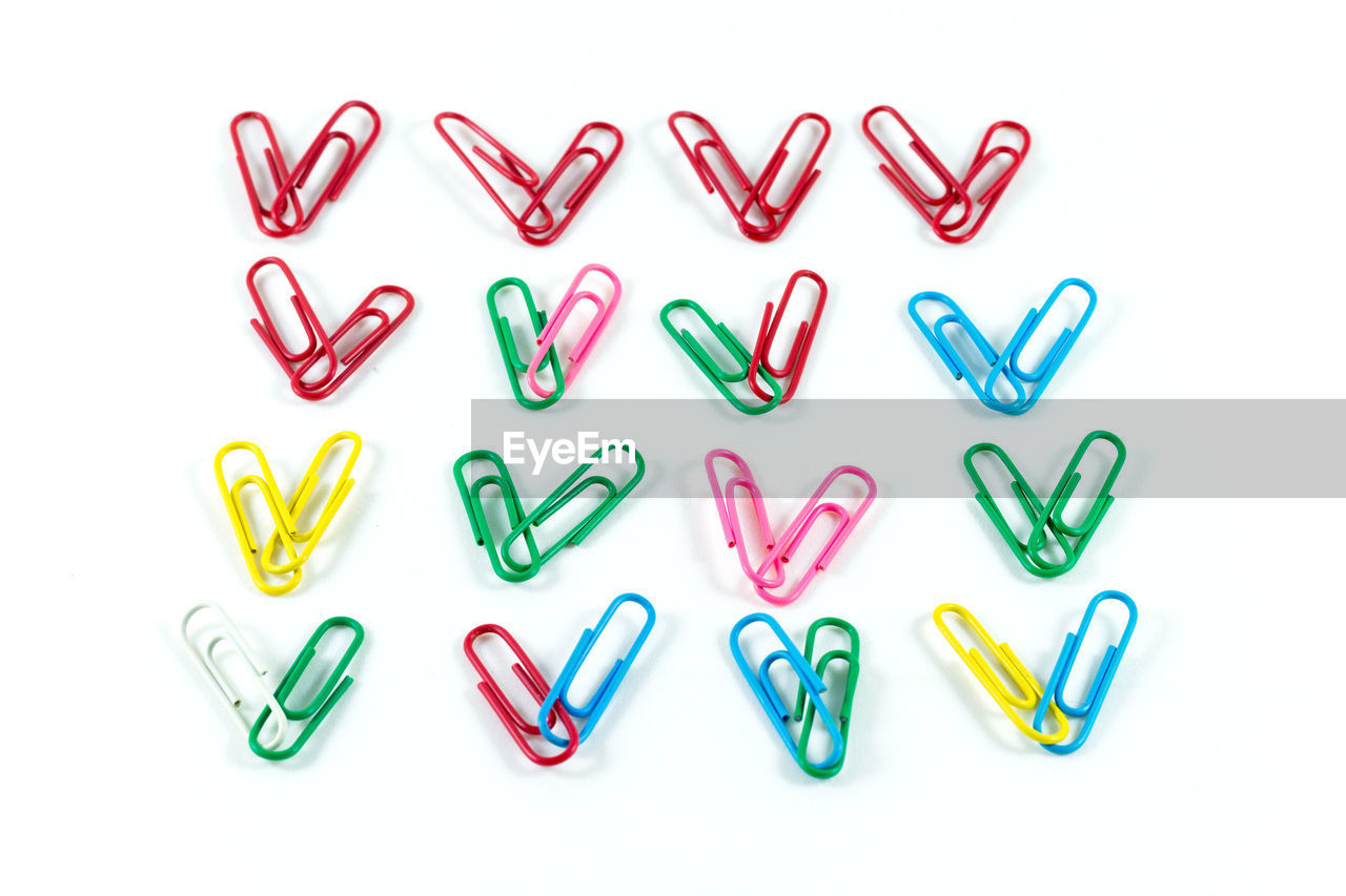 Close-up of colorful paper clips arranged on white background