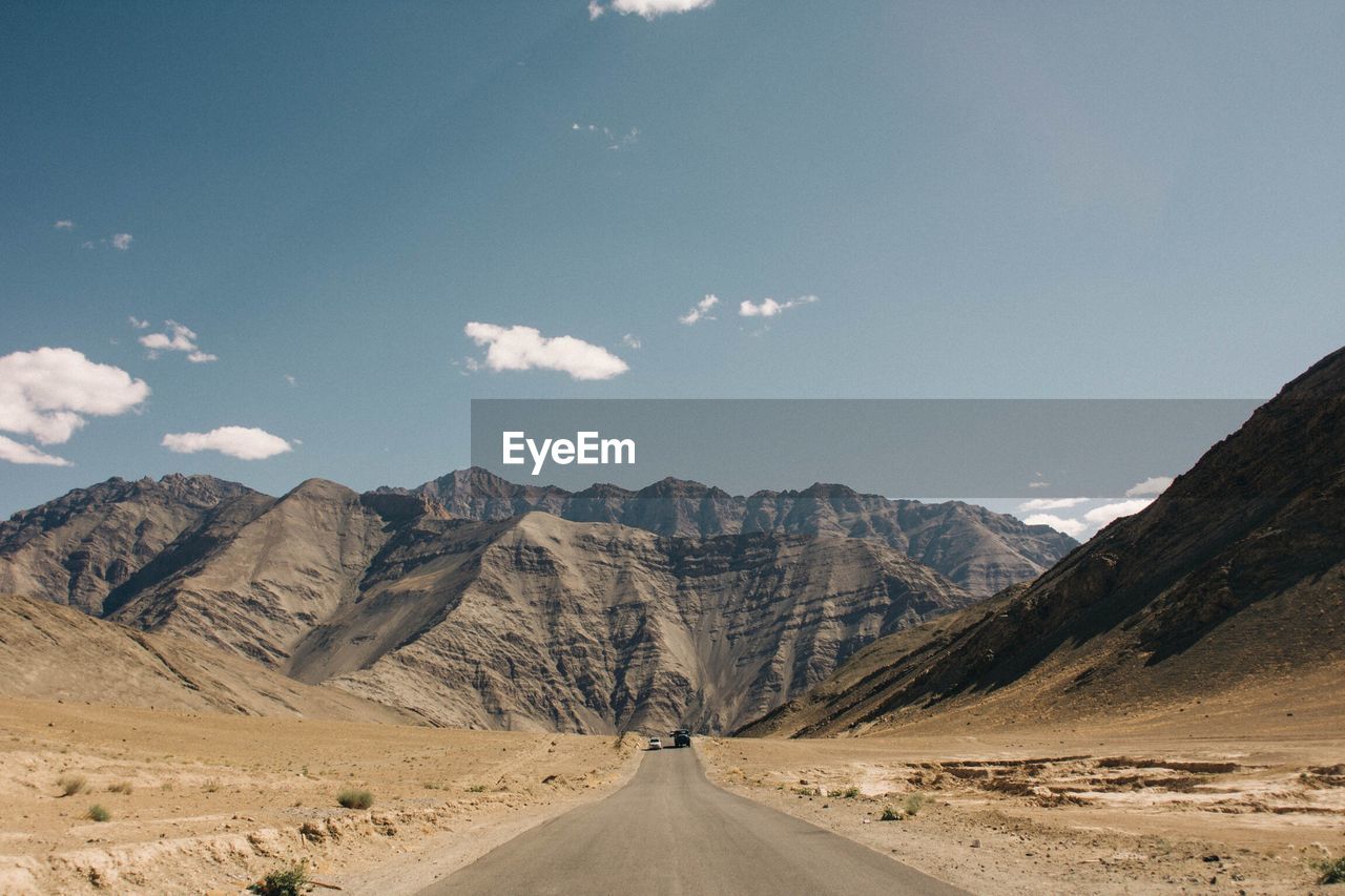 Road amidst mountains against sky