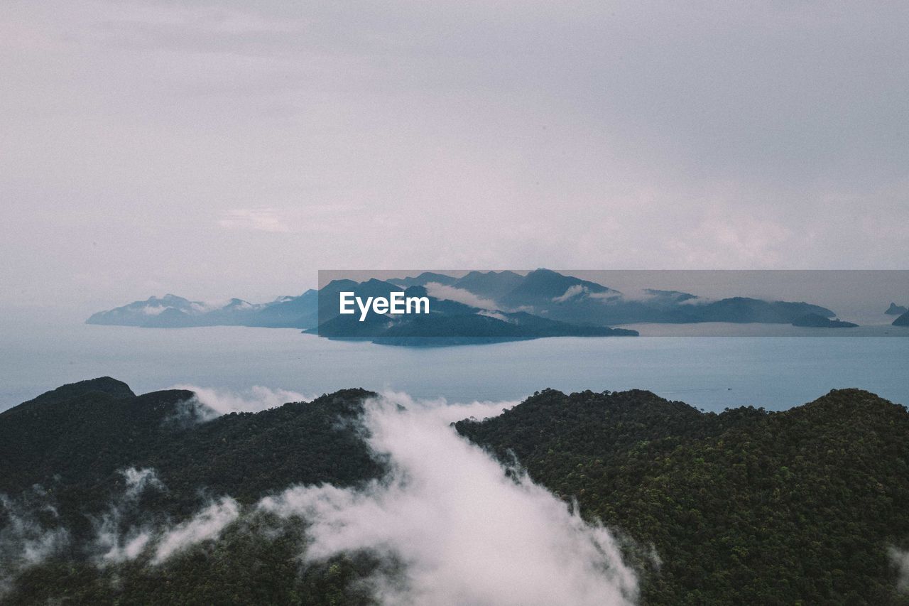 Scenic view of sea and mountains against sky