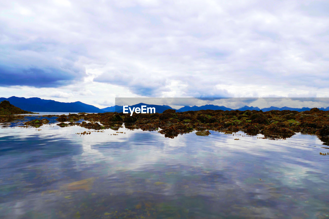 SCENIC VIEW OF LAKE BY MOUNTAINS AGAINST SKY