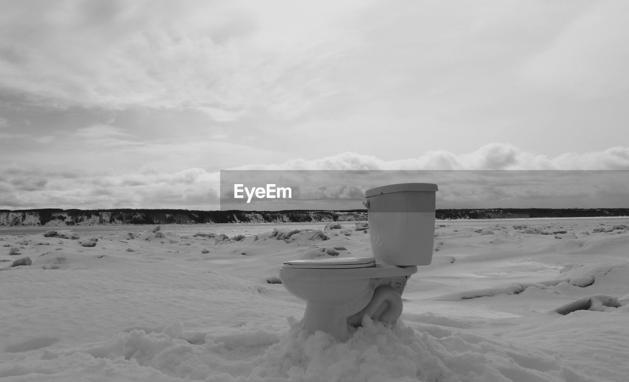 Abandoned commode on snow covered landscape