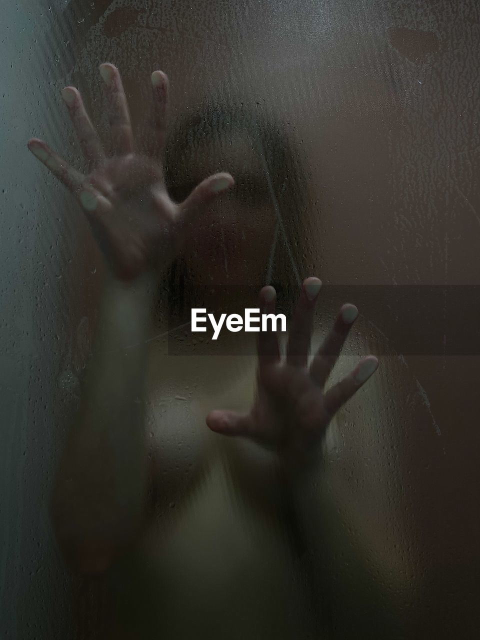 Naked young woman in bathroom seen through window