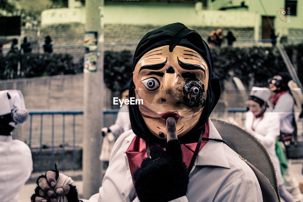 PORTRAIT OF BOY WITH MASK IN BACKGROUND