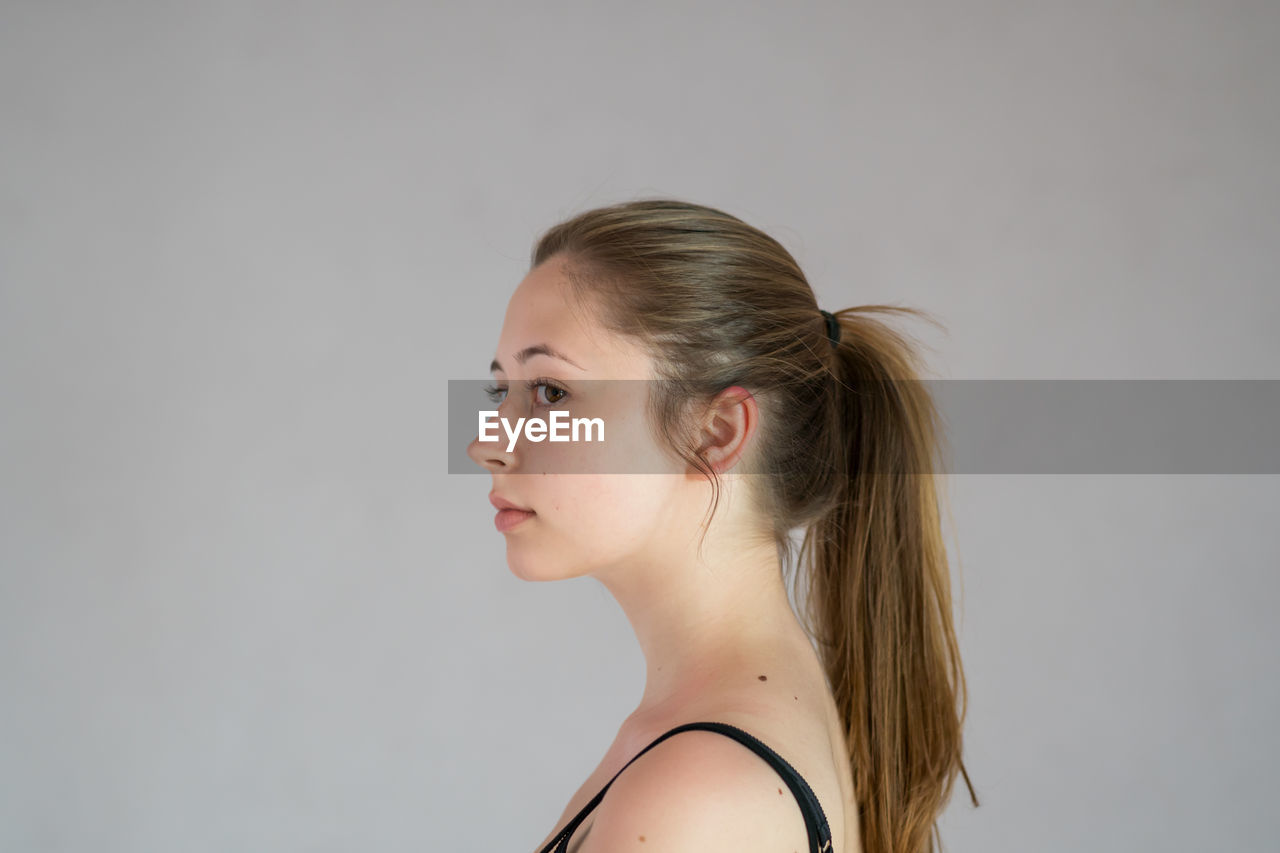 PORTRAIT OF A YOUNG WOMAN OVER WHITE BACKGROUND