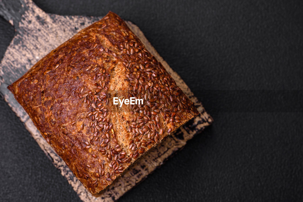 food and drink, food, studio shot, bread, indoors, freshness, no people, high angle view, wellbeing, black background, healthy eating, slice, close-up, brown, directly above, baked, gray background, single object, brown bread