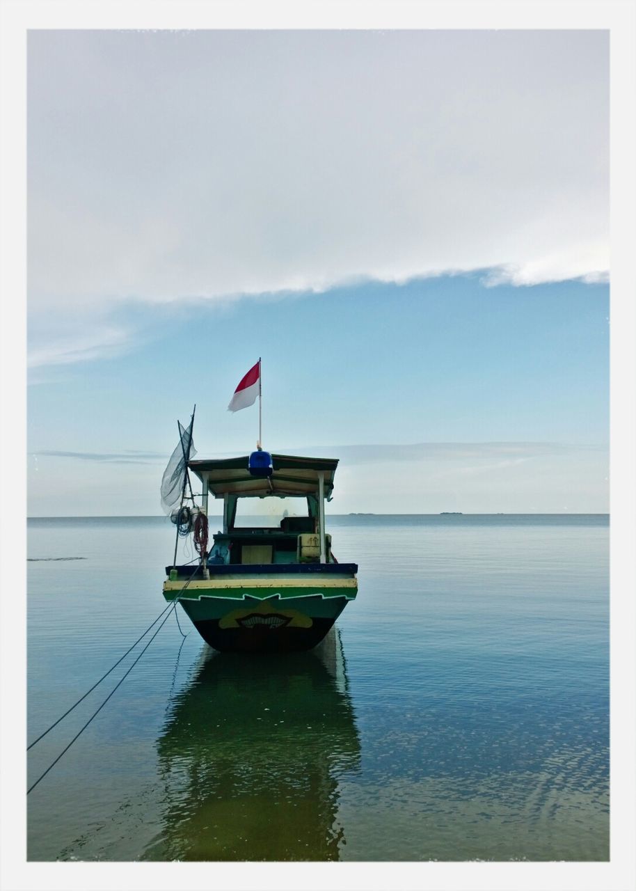 Indonesian flag on boat moored in sea