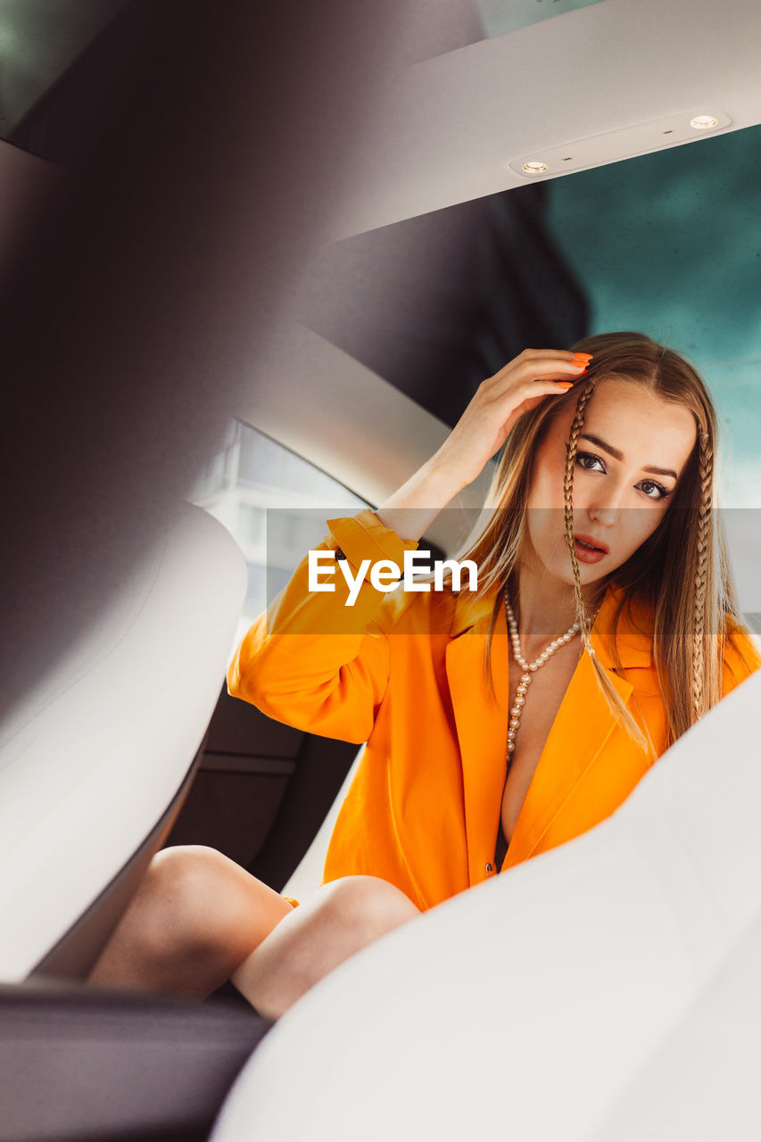 Portrait of young woman sitting on escalator