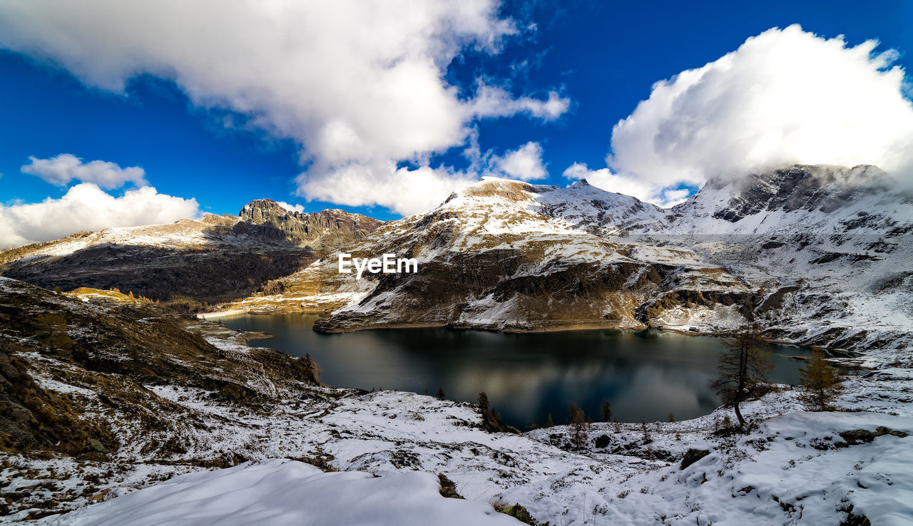 Scenic view of dark water of gemelli lake and snowcapped mountains as frame 