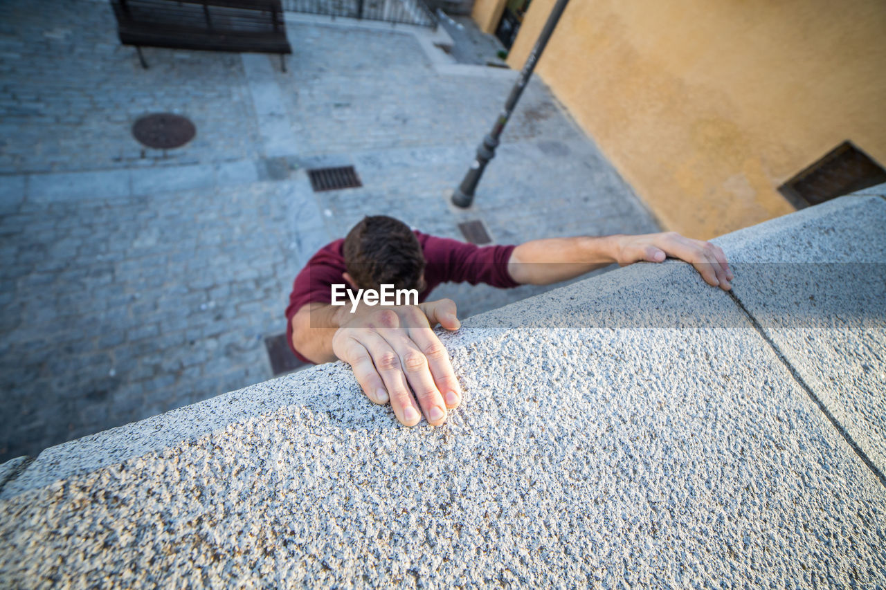 High angle view of man climbing concrete wall