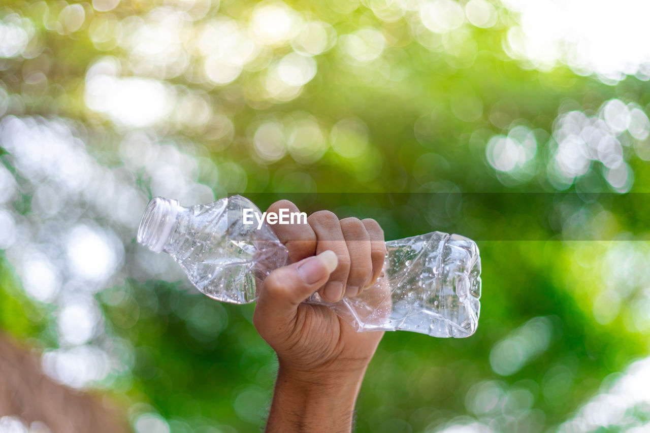 CLOSE-UP OF PERSON HAND HOLDING ICE