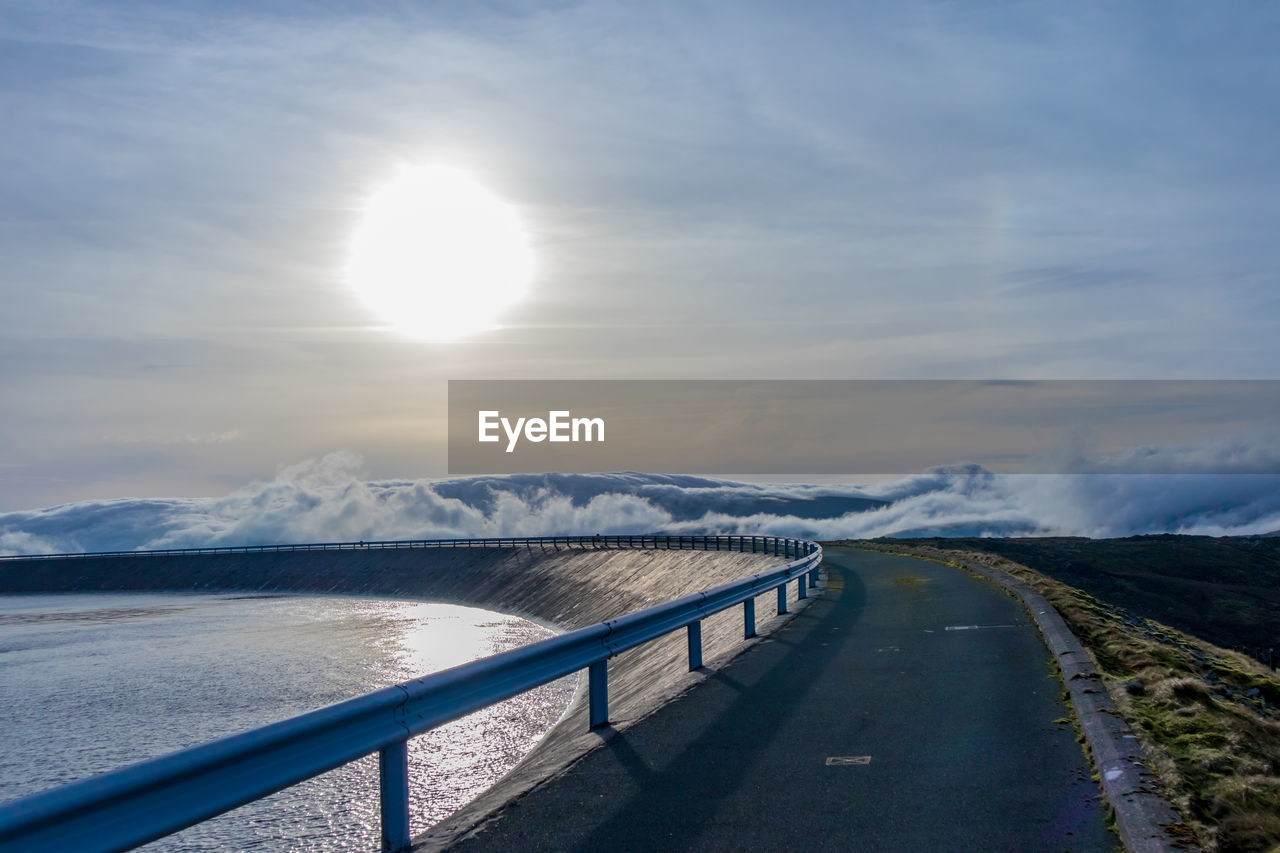 Road by snowcapped mountains against sky during winter