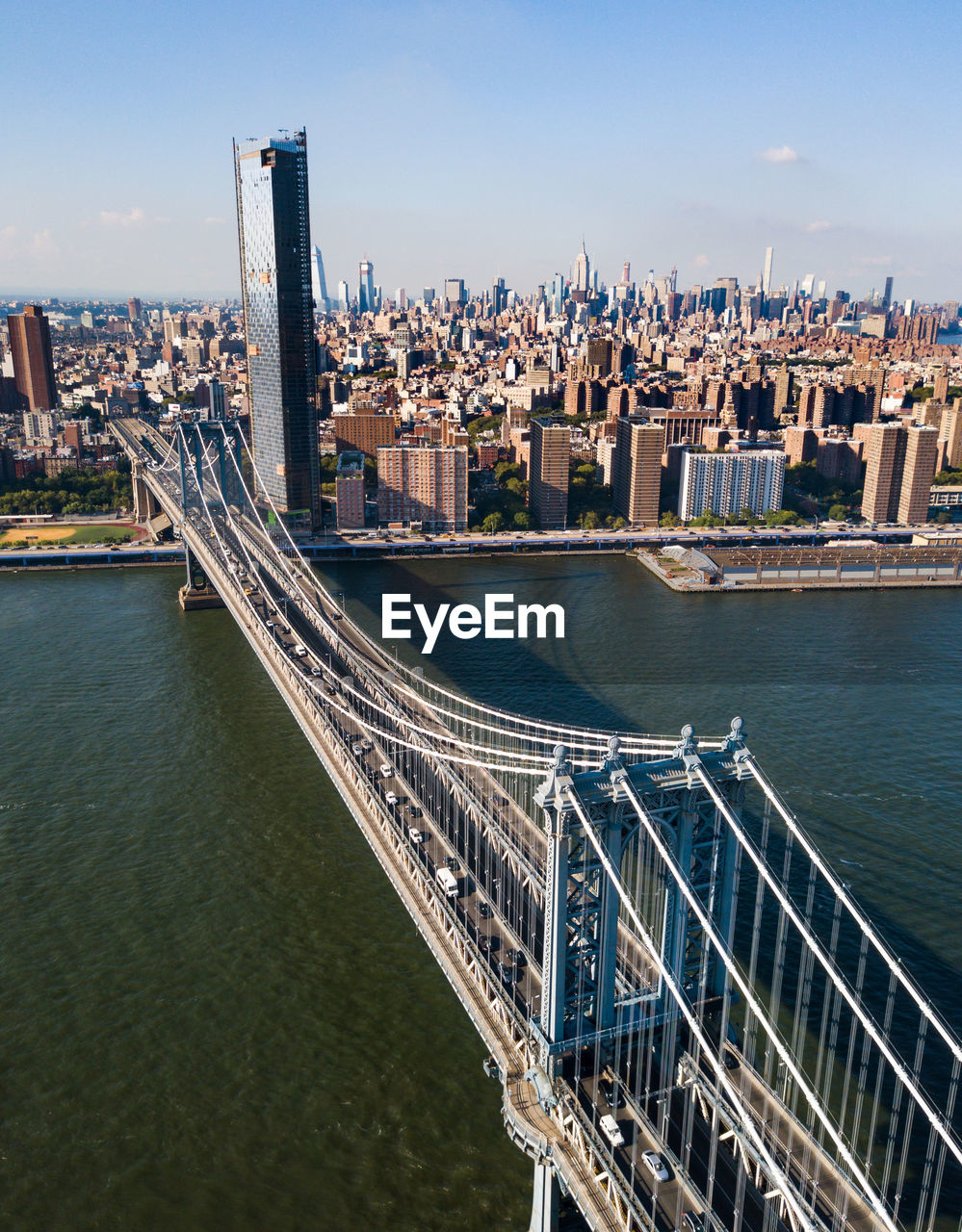 High angle view of manhattan bridge over river by buildings against sky