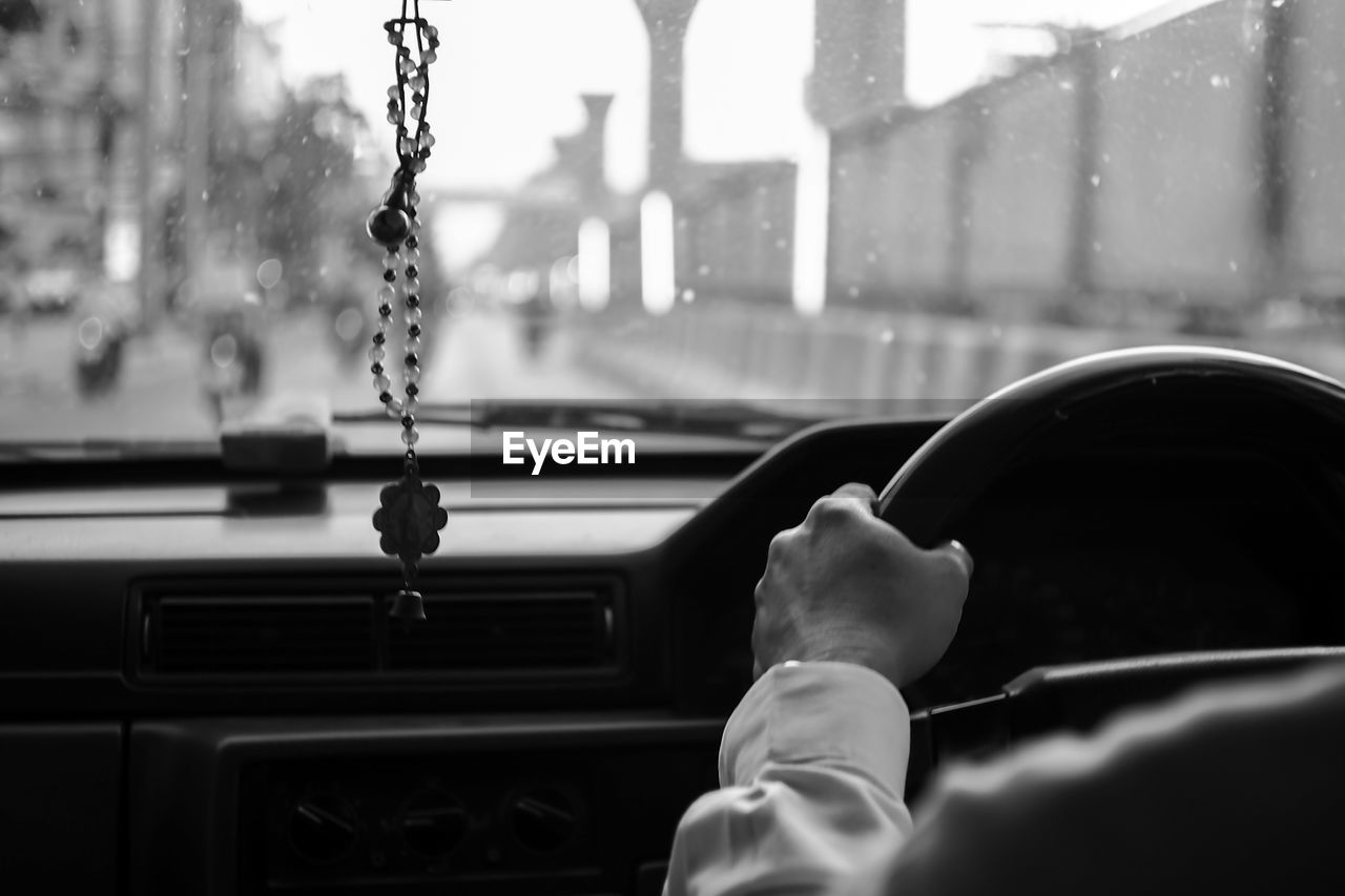 Cropped image of person driving car