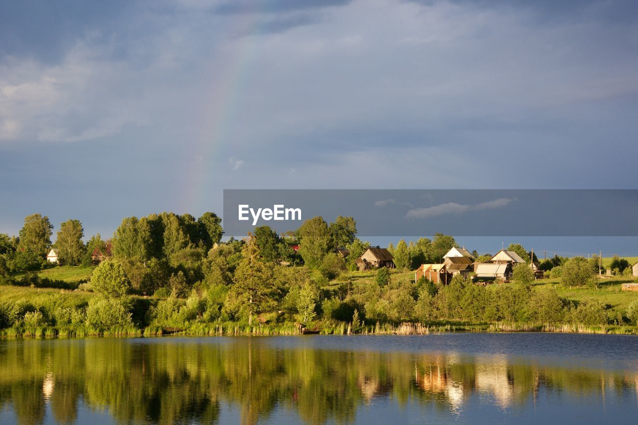 Scenic view of lake in front of trees against sky