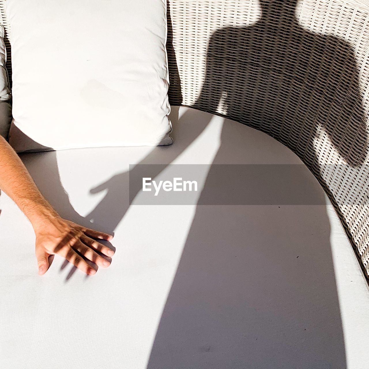 Cropped hand of man with girlfriend shadow on seat