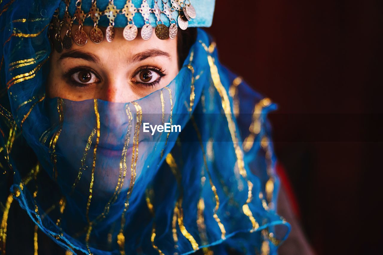 Portrait of beautiful woman covering face with traditional scarf