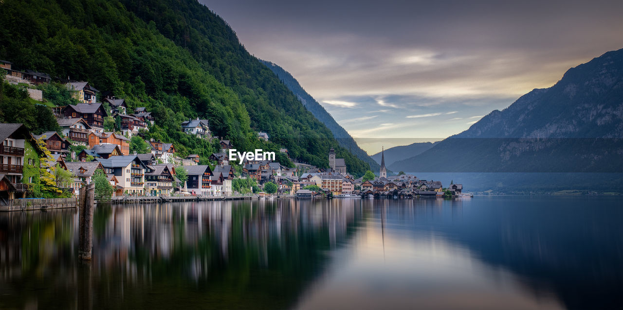 Scenic view of lake by buildings against sky