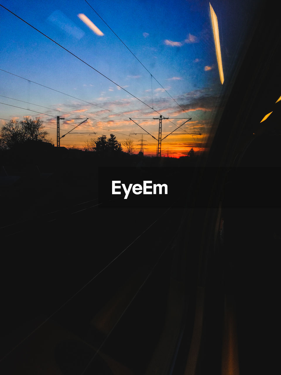 RAILROAD TRACKS AGAINST SKY DURING SUNSET