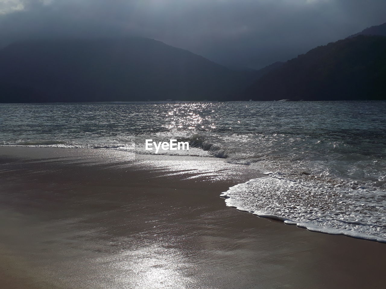 SCENIC VIEW OF SEA BY MOUNTAIN AGAINST SKY