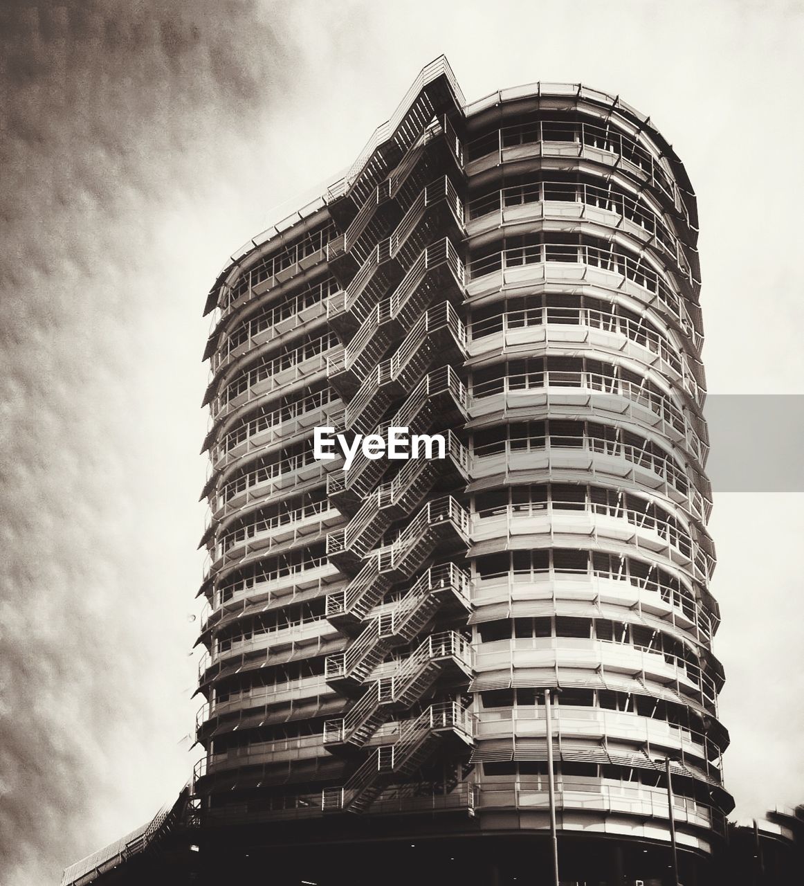 LOW ANGLE VIEW OF MODERN BUILDINGS AGAINST CLOUDY SKY