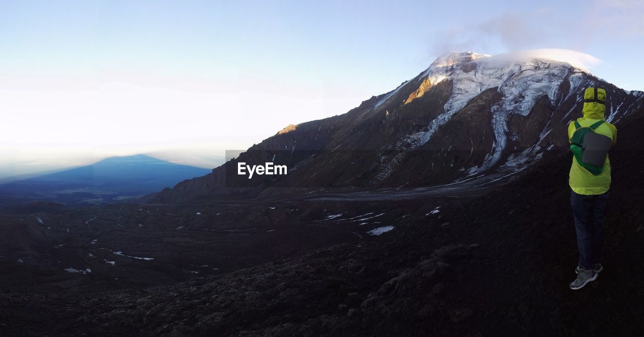 Woman with mountain range against sky