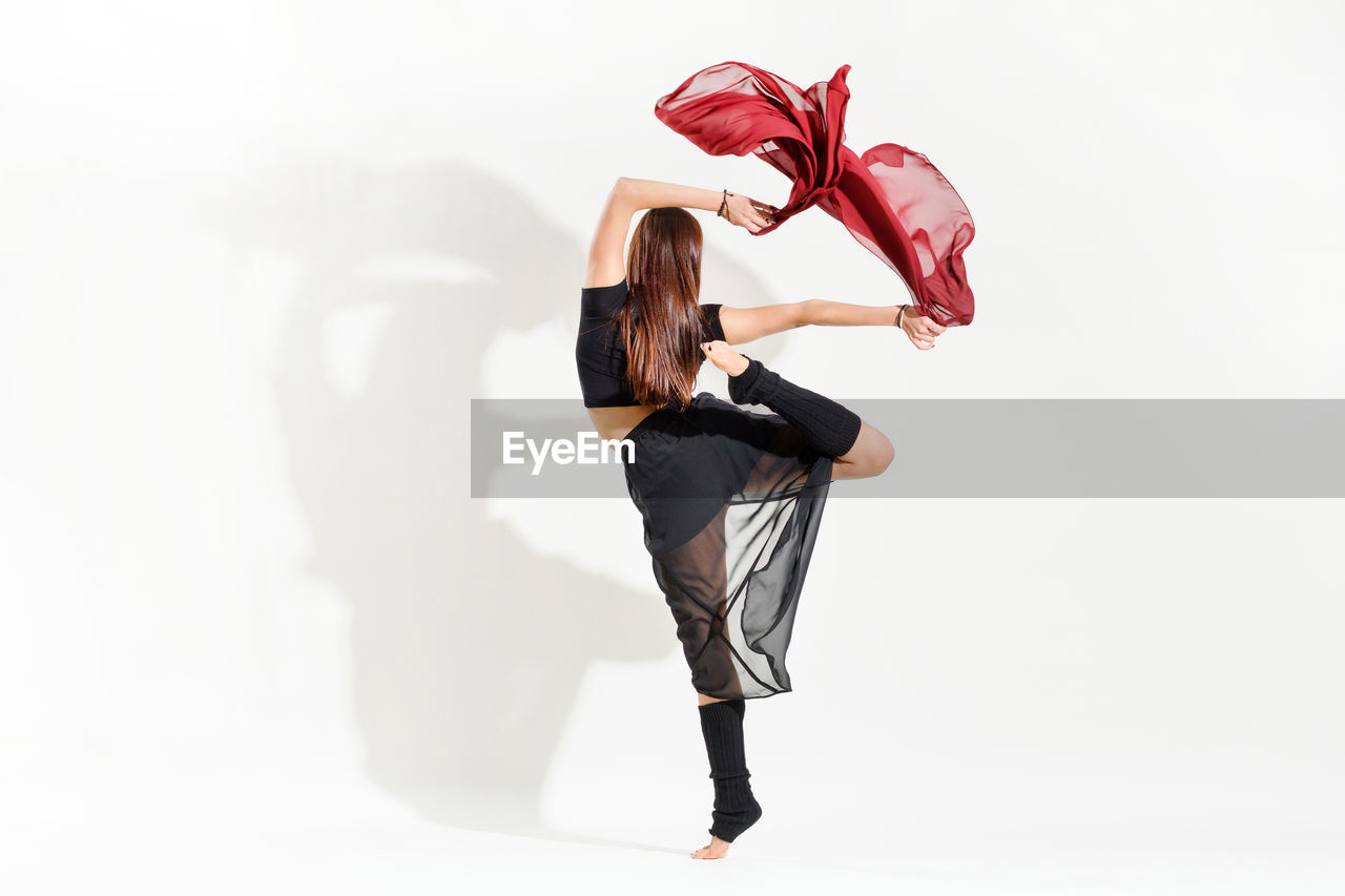 REAR VIEW OF WOMAN WITH RED HAIR AGAINST WHITE BACKGROUND