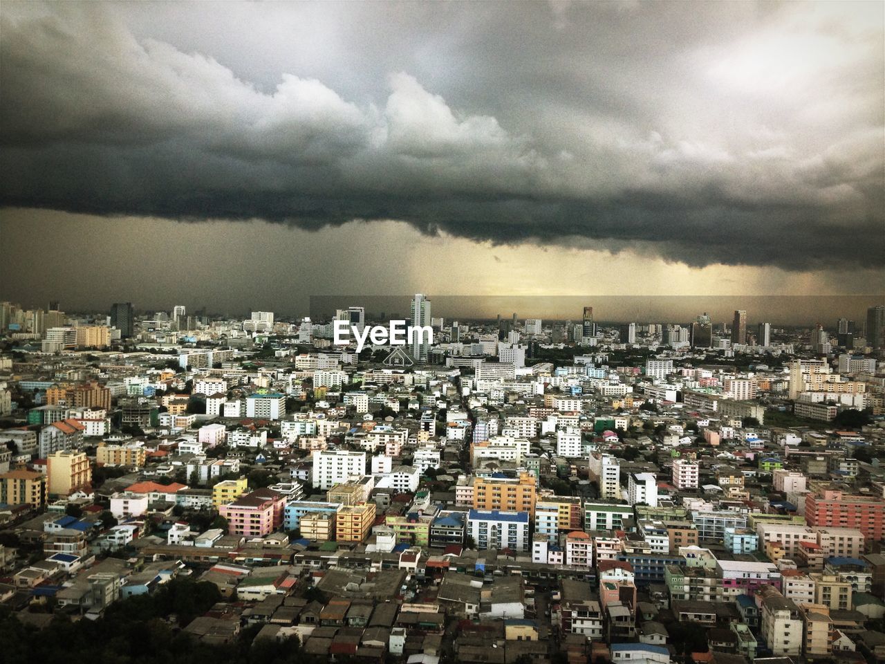 High angle shot of cityscape against clouds