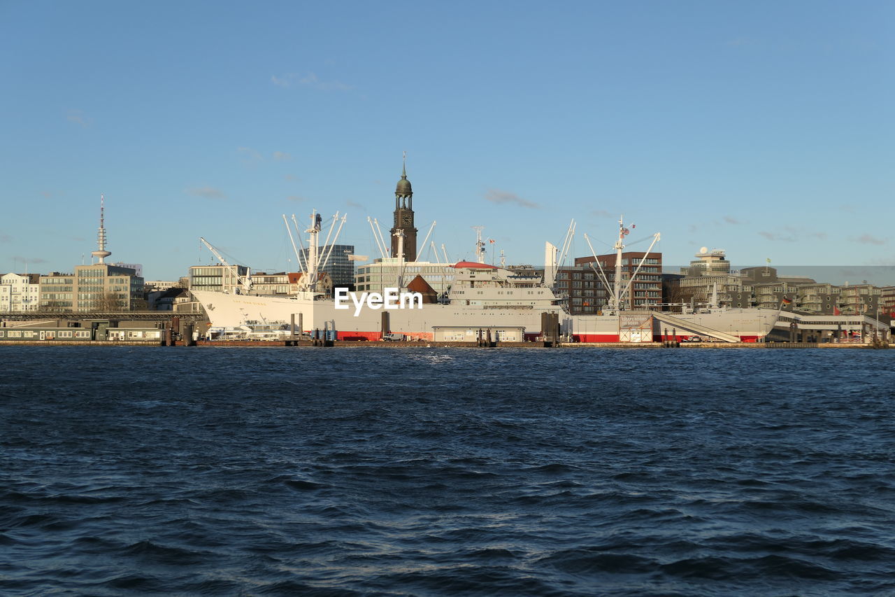 SEA WITH BUILDINGS IN BACKGROUND