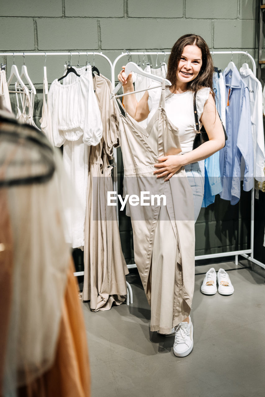 Fast fashion, woman shopping in cloth store. shopping trendy clothes.