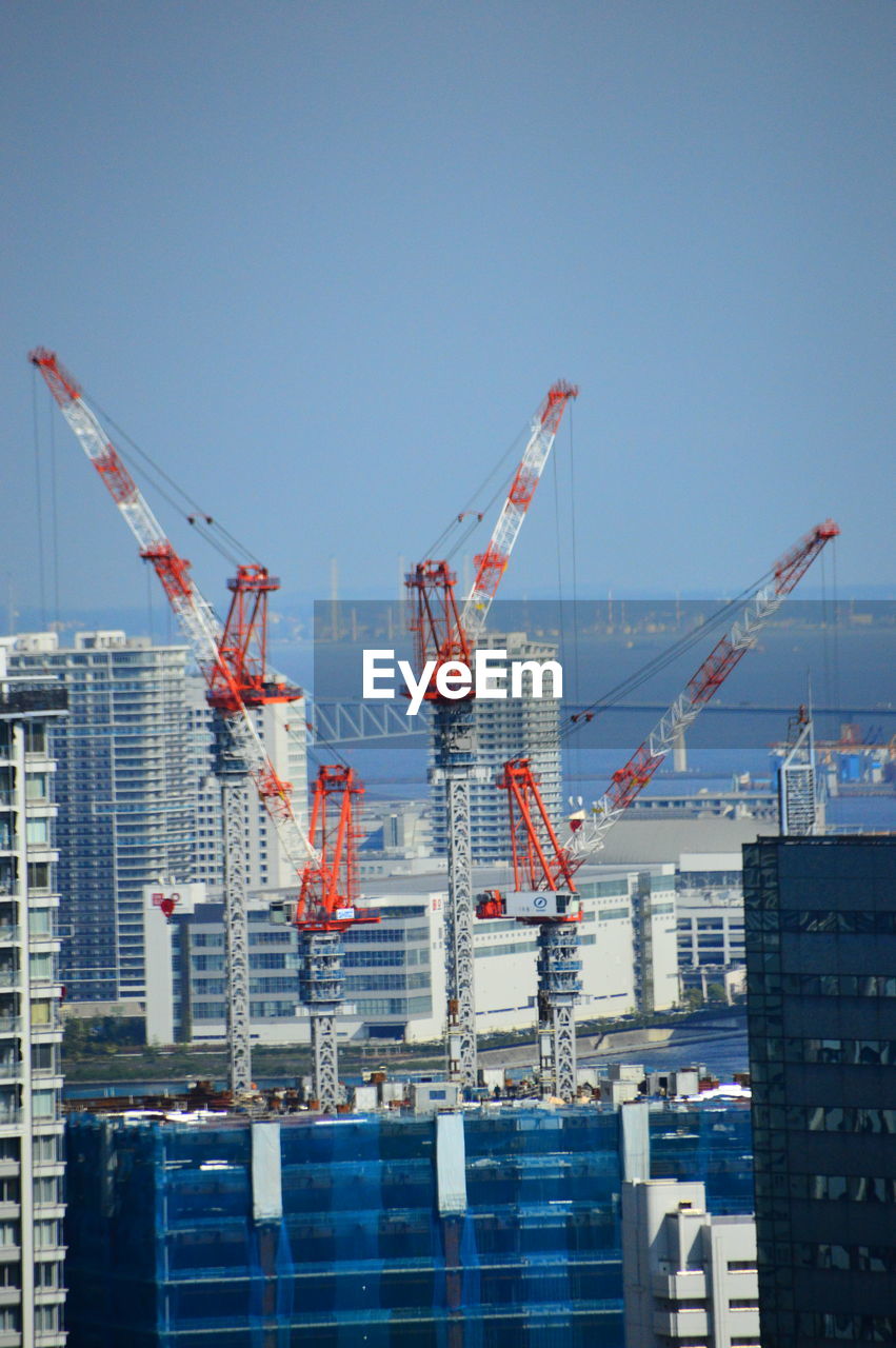 Low angle view of cityscape against clear blue sky